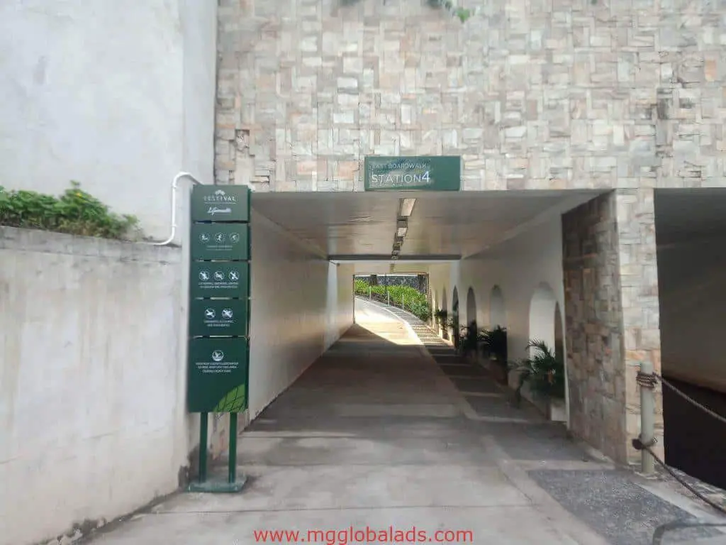 Wayfinding and directional signage at Station 4 walkway in a stone building, Makati, with plants. By M&G Global Ads.