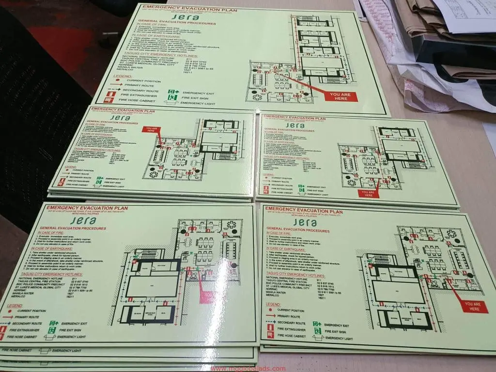 Laminated emergency evacuation plan signage for Ortigas, with floor maps and safety routes, by M&G Global Ads.