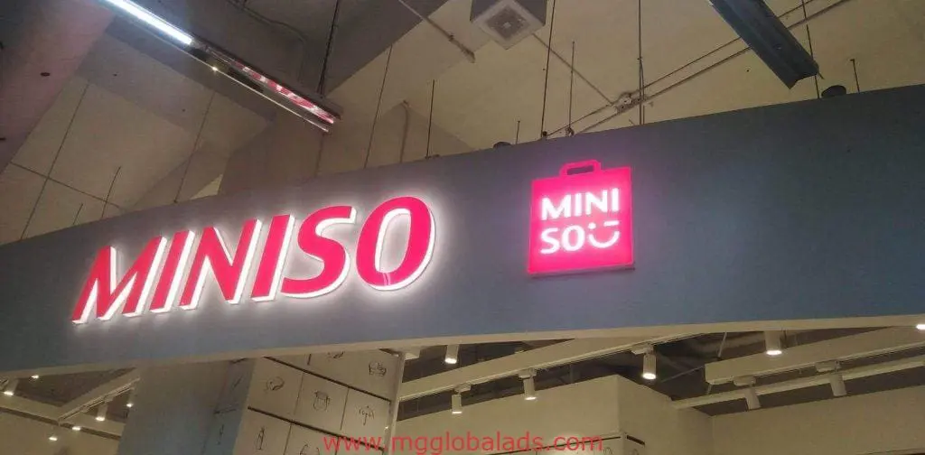 MINISO outdoor store signage with red shopping bag logo in Mandaluyong, bright white/red letters, by M&G Global Ads.