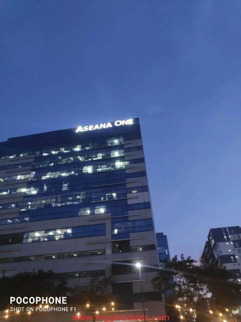 Metallic building signage ASEANA ONE on office tower at dusk in Makati, illuminated windows, by M&G Global Ads.
