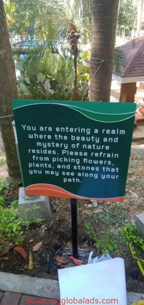 Metallic garden sign with nature message at a Makati property, reminding not to pick flowers or stones. By M&G Global Ads.
