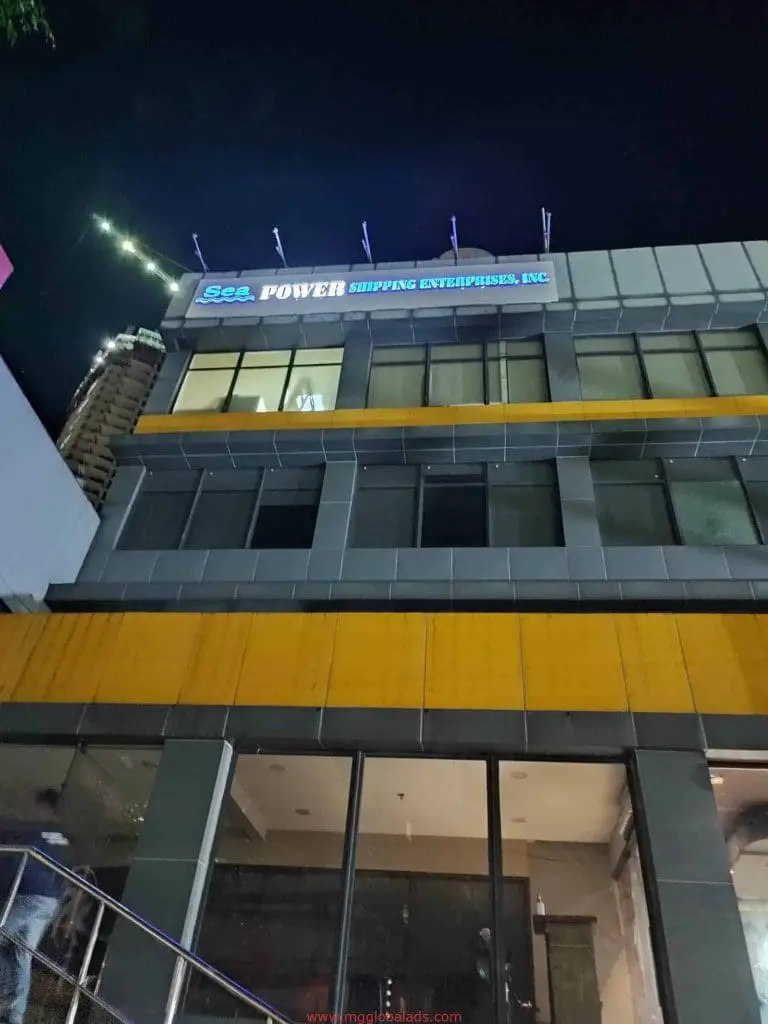 Illuminated LED signage Sea Power Shipping Enterprises, Inc. on 3-story building facade in Makati at night by M&G Global Ads.