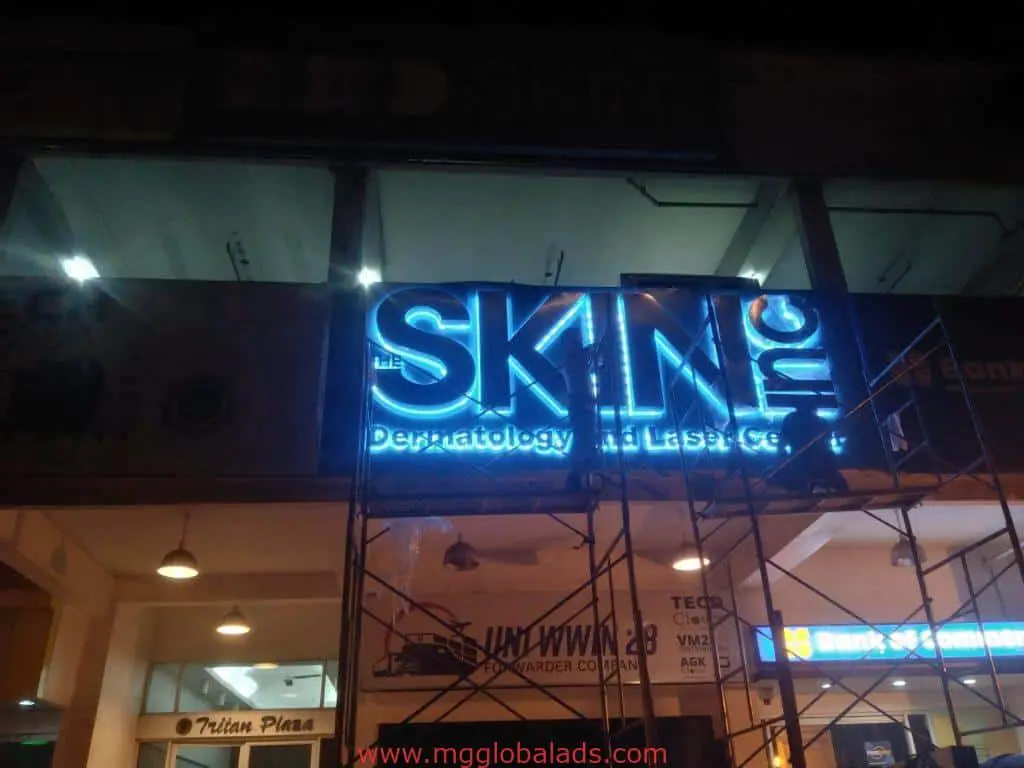 Illuminated metallic building signage for SKIN Inc Dermatology in Ortigas at night, with scaffolding, by M&G Global Ads.