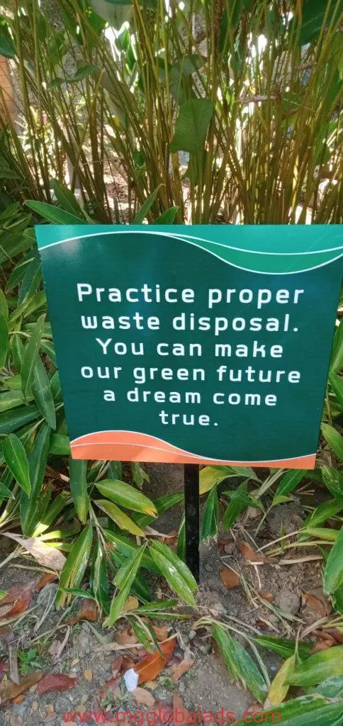 LED signage in Quezon City displays Practice proper waste disposal... among plants, by M&G Global Ads.