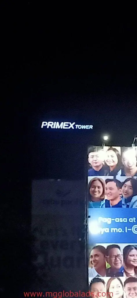 PRIMEX TOWER LED signage on a building at night and a billboard with smiling people in Ortigas, by M&G Global Ads.