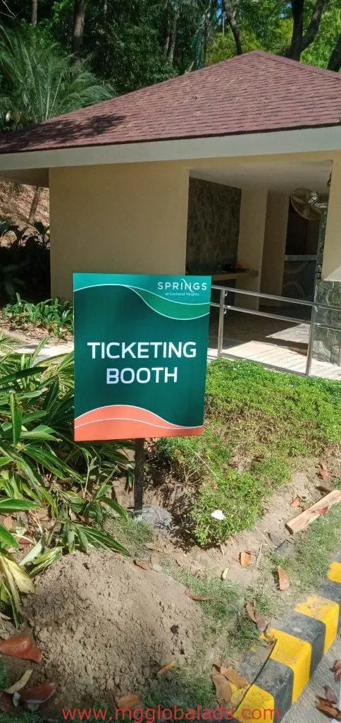 Green metallic ticketing booth signage at Springs with tiled roof, Quezon City location, by M&G Global Ads.