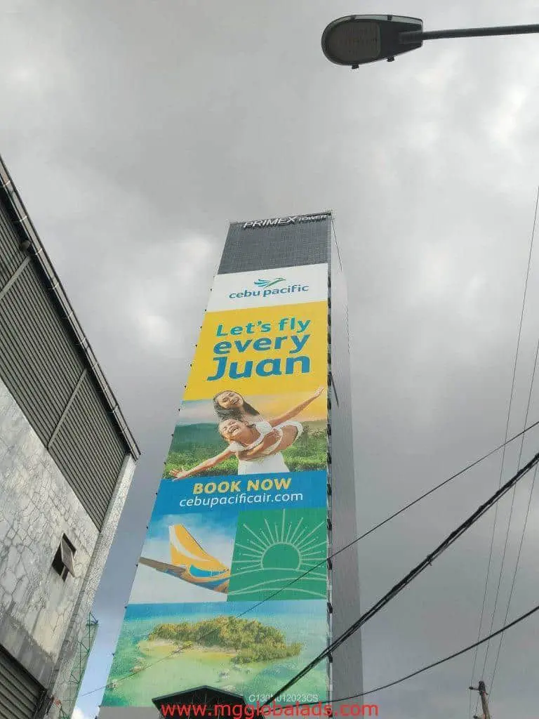 Cebu Pacific acrylic signage with Let’s fly every Juan on building in Makati, beach ad image below; by M&G Global Ads.