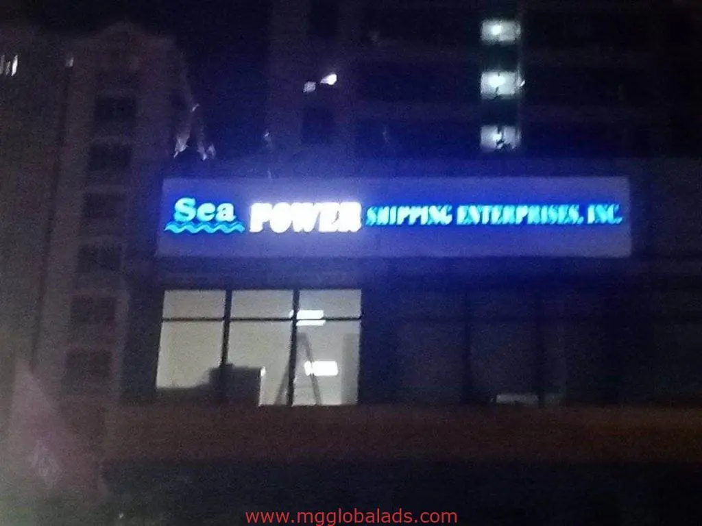 Sea POWER Shipping Enterprises, Inc. LED signage on building at night in Makati, glowing blue and white by M&G Global Ads.