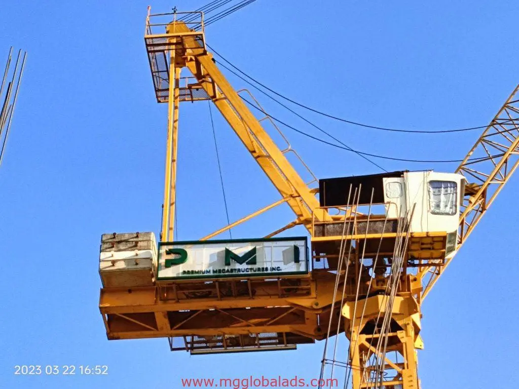 Acrylic PMSI signage on yellow crane in Quezon City, blue sky, steel bars, 2023-03-22. By M&G Global Ads.