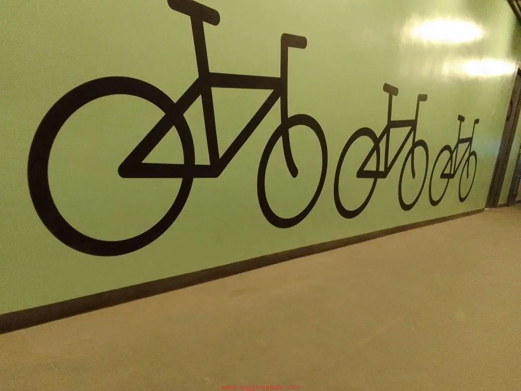 Modern indoor office wall signage featuring black minimalist bicycle line art in a Makati hallway, by M&G Global Ads.