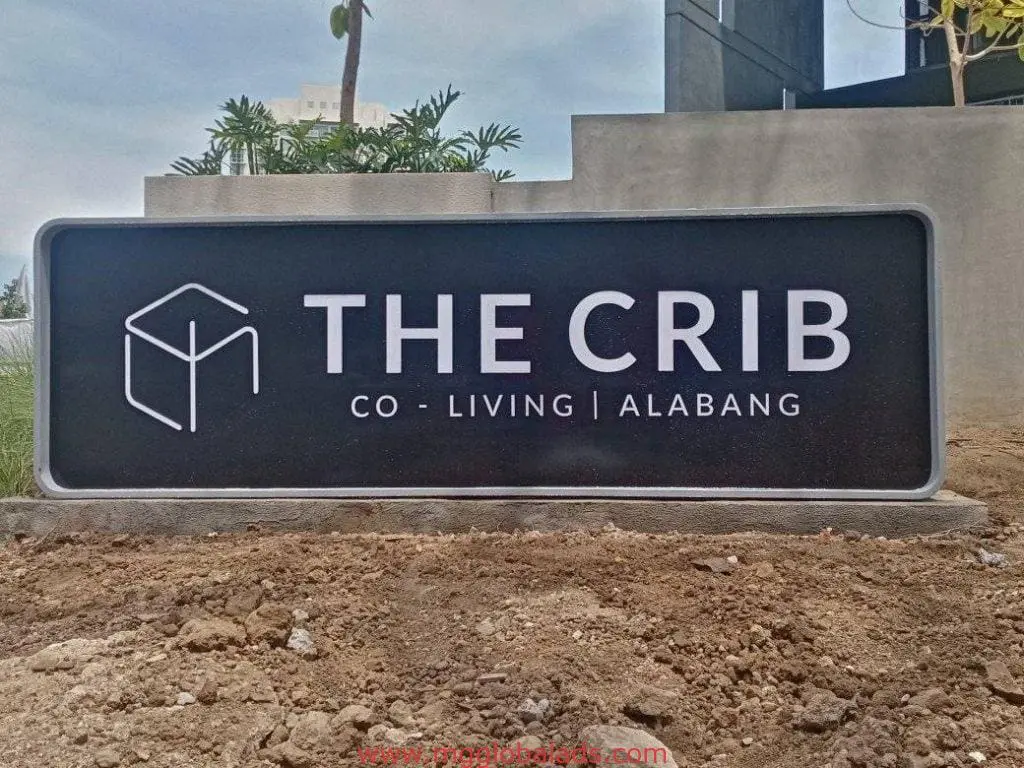Rectangular building signage for THE CRIB CO - LIVING | ALABANG in Makati, with geometric logo, by M&G Global Ads.