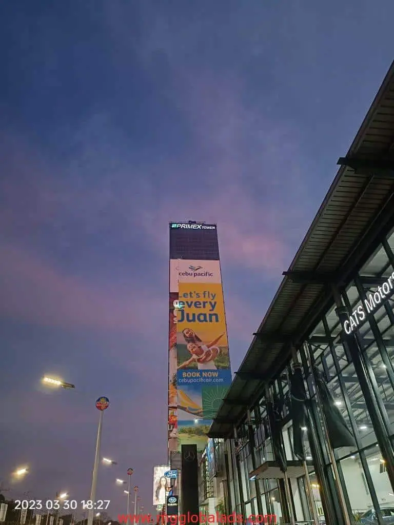Cebu Pacific LED signage on tall building in Makati with let’s fly every Juan slogan at dusk, by M&G Global Ads.
