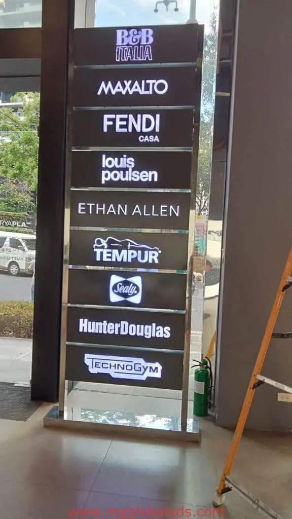 Indoor vertical building signage featuring logos of B&B Italia and more in Makati, fire extinguisher at base by M&G Global Ads.