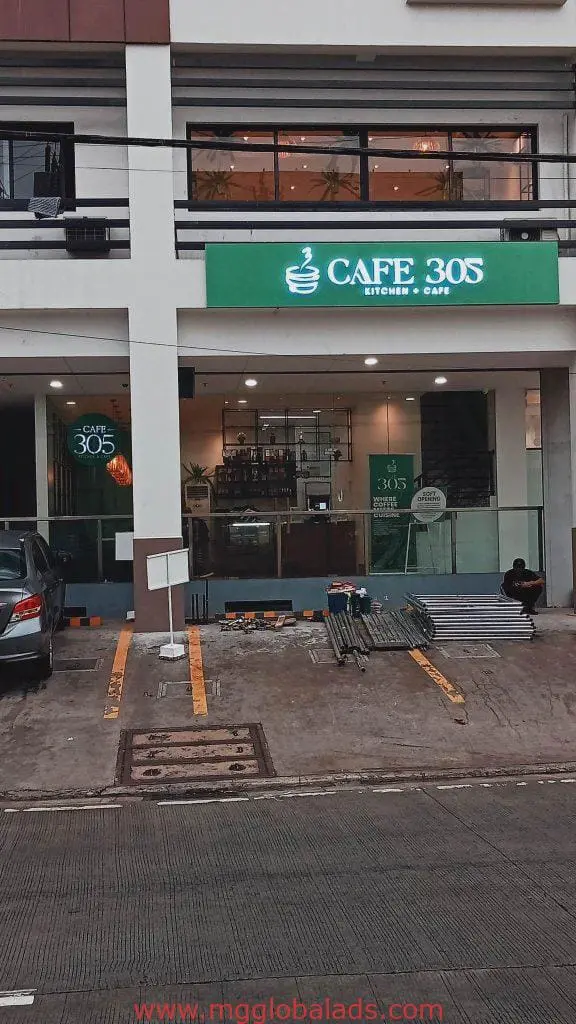 Cafe 305 Kitchen & Cafe green acrylic building signage in Makati with man by steps and parked car, by M&G Global Ads.