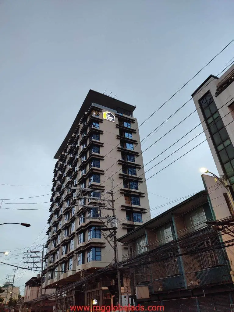 Modern apartment building with LED advertising signage in Makati, multiple balconies, dusk sky—by M&G Global Ads.
