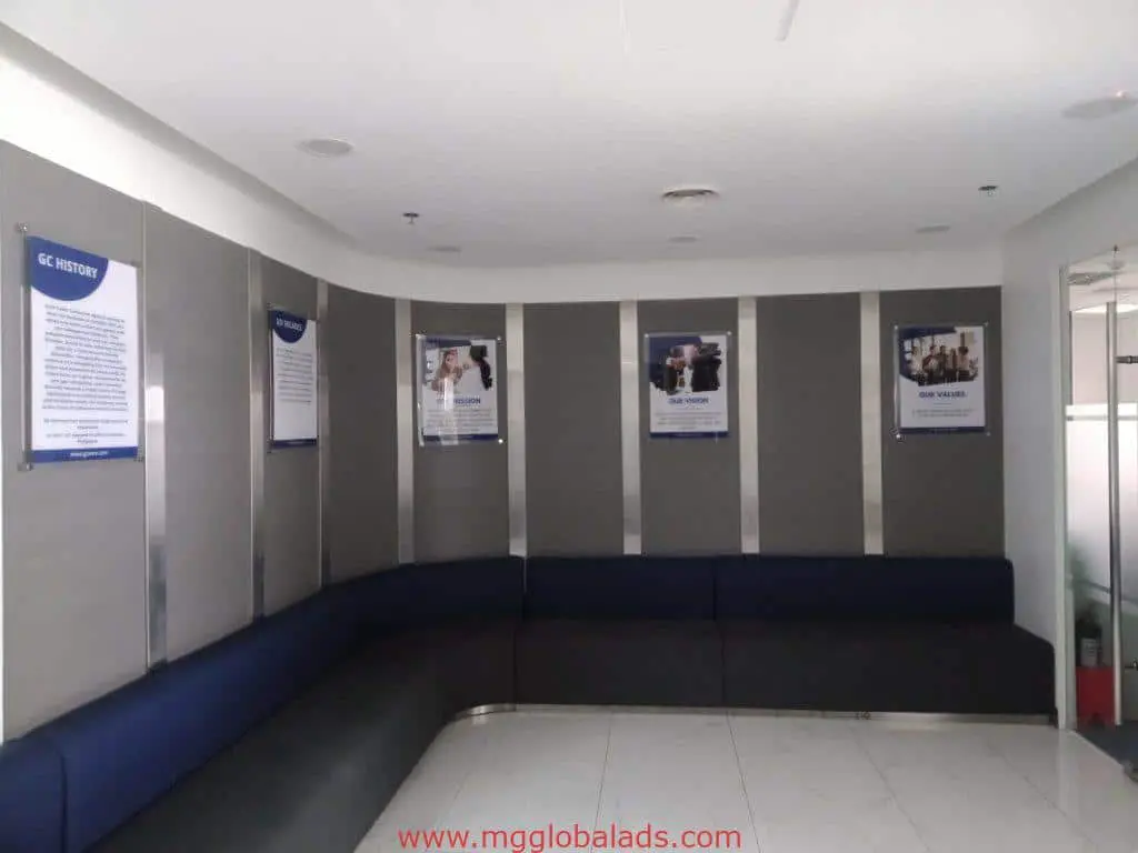Modern office waiting area with metallic wayfinding signage in Makati, gray walls, blue benches, ample lighting by M&G Global Ads.