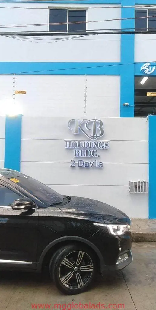 Acrylic signage for KB Holdings at a white and blue building in Quezon City, Metro Manila by M&G Global Ads.