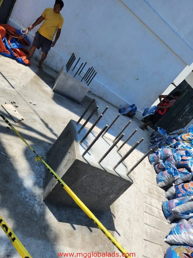Metal signage installation with caution tape by a white wall, Quezon City outdoor area, by M&G Global Ads.