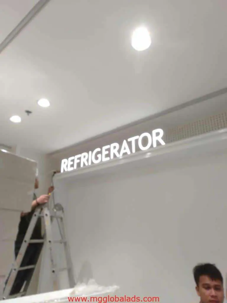 LED signage installation for REFRIGERATOR on white wall in Makati, with two workers visible, by M&G Global Ads.