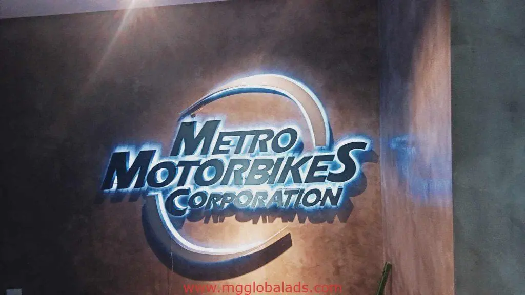 LED building signage for Metro Motorbikes Corporation in Makati, glowing on textured wall by M&G Global Ads.
