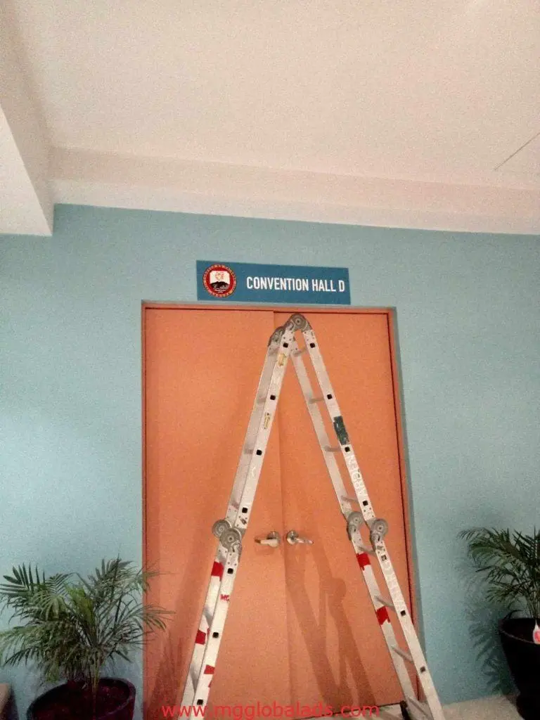 Building signage for Convention Hall D at a venue in Ortigas, featuring entrance doors and plants, by M&G Global Ads.