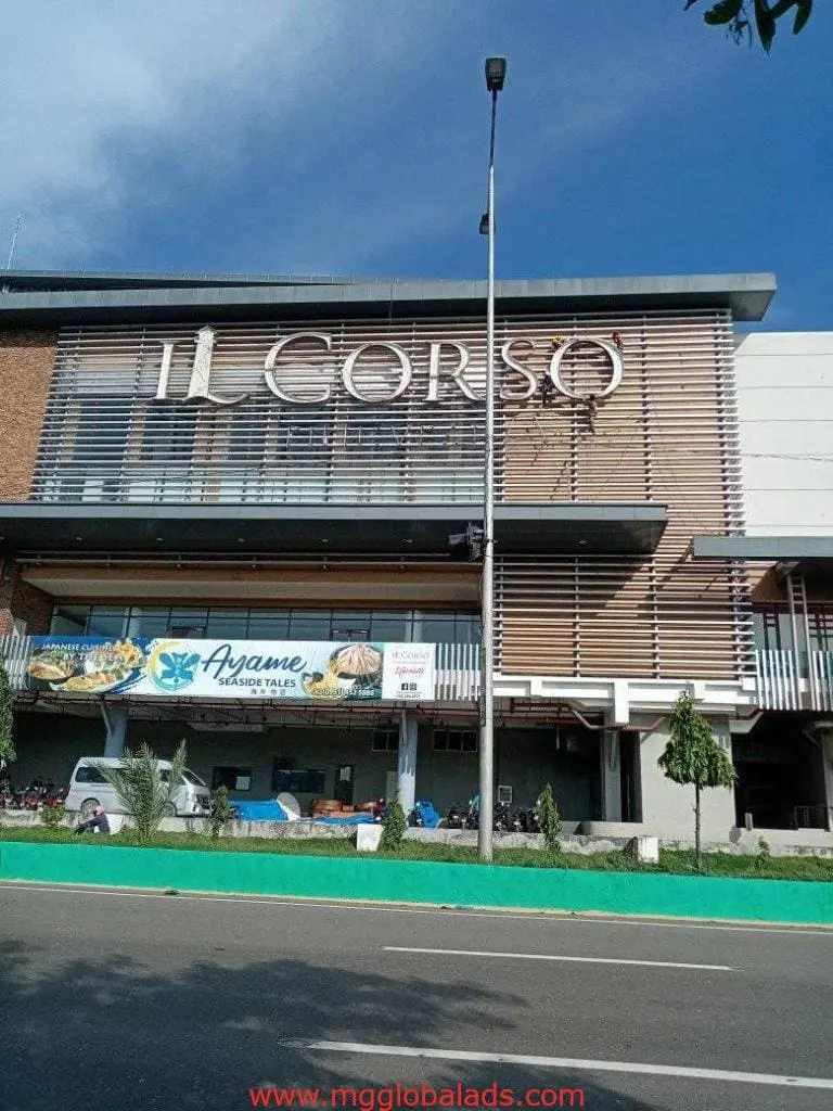 Metallic IL CORSO building signage and Ayame Sushi Tai banners in Quezon City, motorcycles in front by M&G Global Ads.
