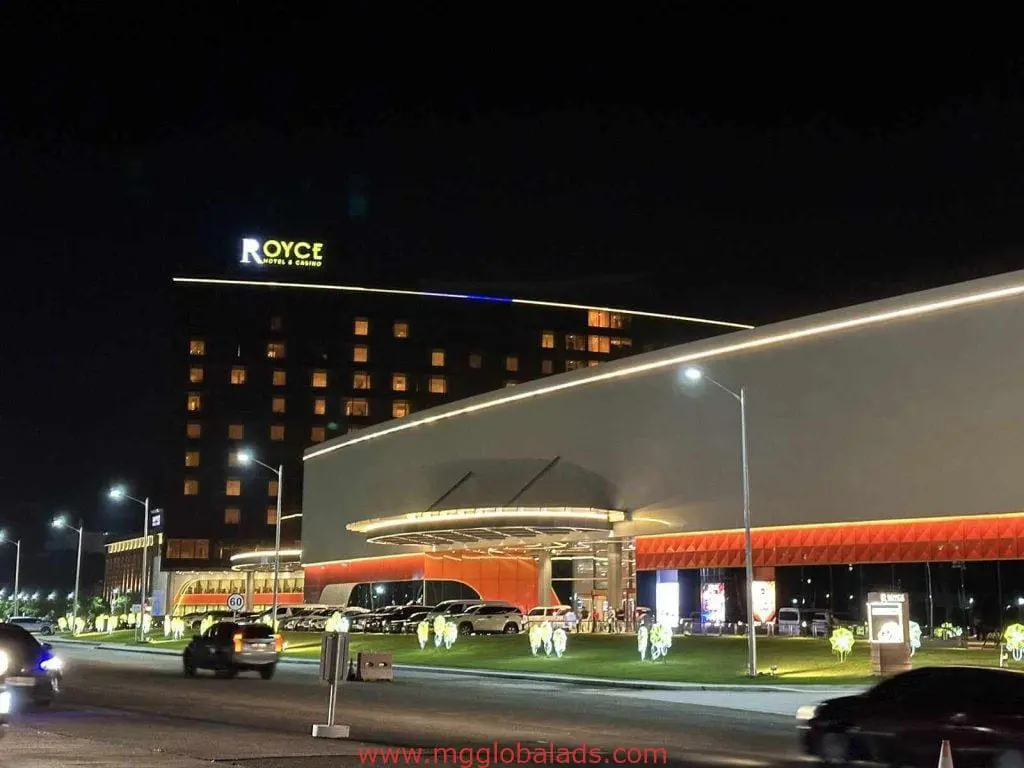 LED building signage for Royce Hotel & Casino in Quezon City at night, cars and lights visible. By M&G Global Ads.