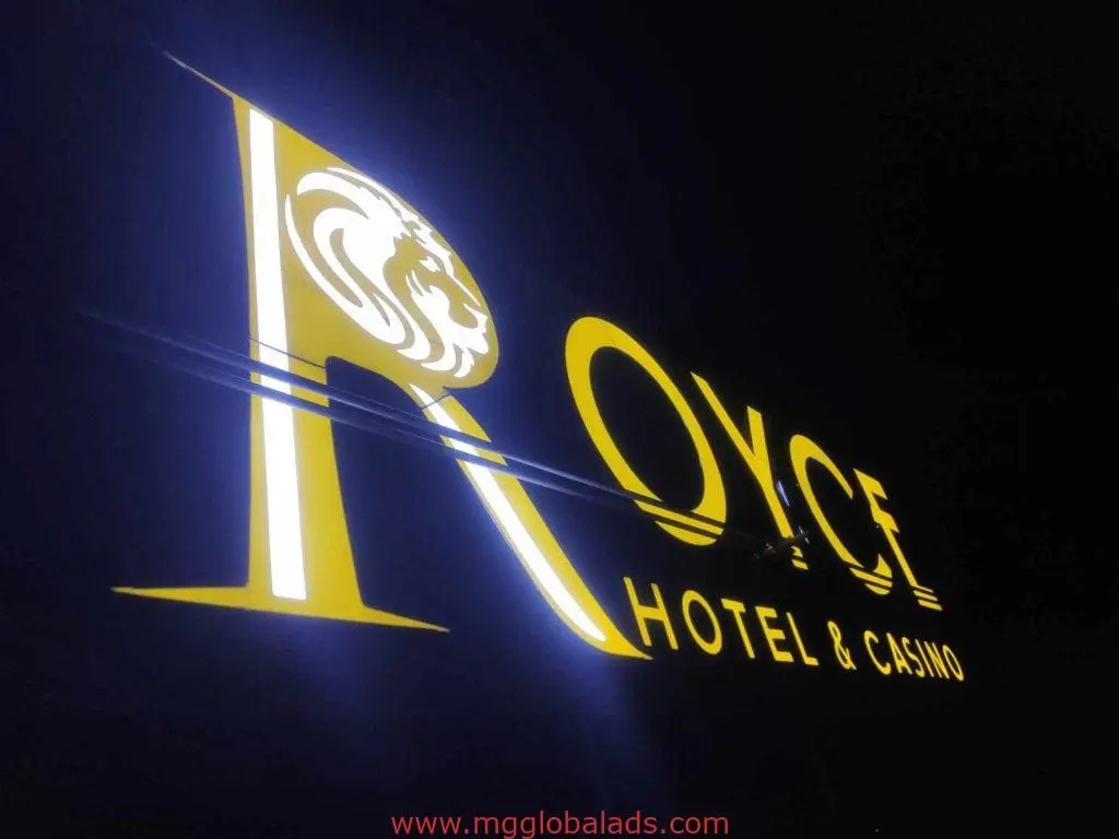 Metallic hotel signage for Royce Hotel & Casino, bright yellow on black, installed in Ortigas at night by M&G Global Ads.