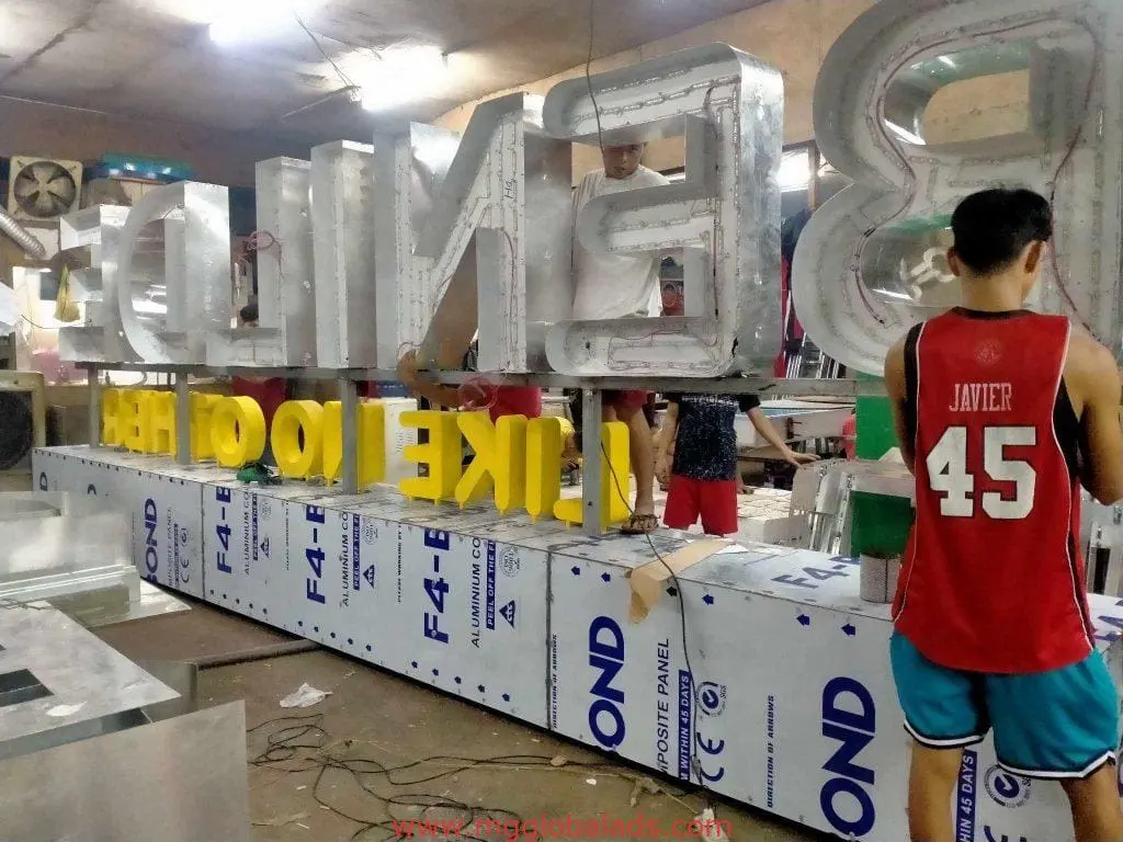 Fabricating stainless steel building signage letters for a Makati business, staff working in workshop by M&G Global Ads.