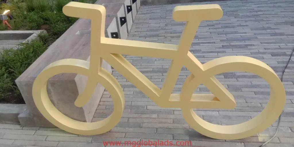 Minimalist yellow bicycle sculpture outdoor signage on a walkway in BGC, Metro Manila, by M&G Global Ads.