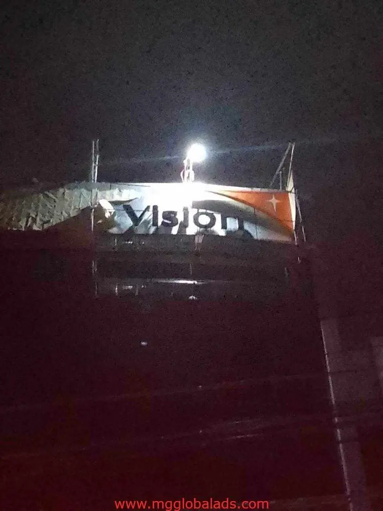 Outdoor metallic Vision signage installation in Makati at night, construction scene by M&G Global Ads.
