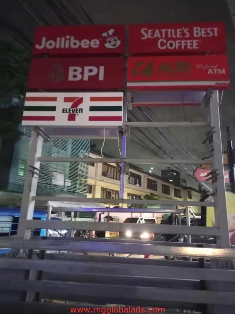 Illuminated pylon signage for Jollibee, Seattle’s Best Coffee, BPI & 7-Eleven in Makati at night, by M&G Global Ads.