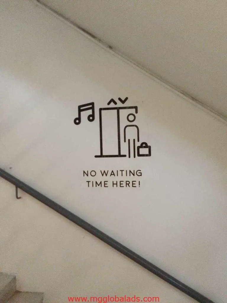 Metallic building signage with elevator icon and NO WAITING TIME HERE! text, in BGC location by M&G Global Ads.
