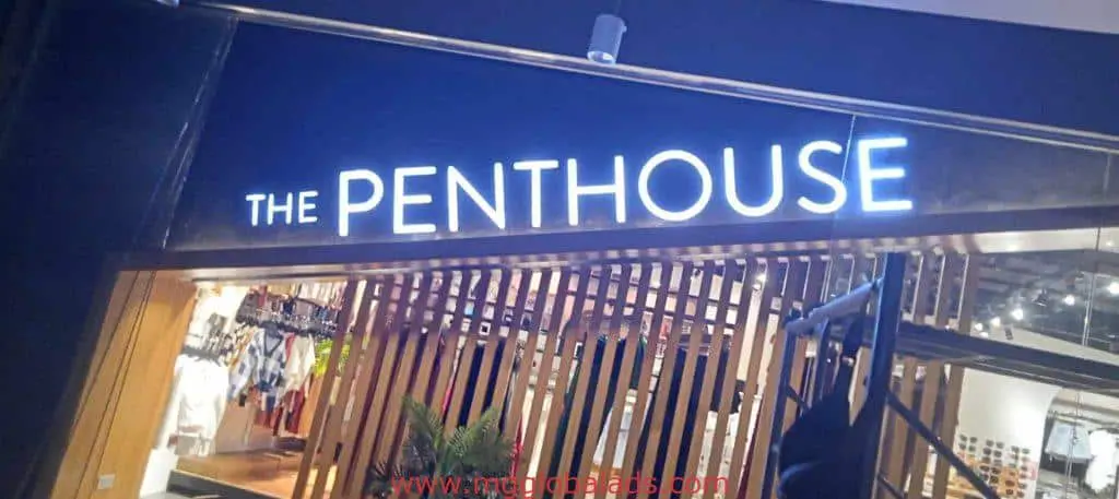 Acrylic building signage THE PENTHOUSE at modern storefront in BGC, with wood slats and plants, by M&G Global Ads.