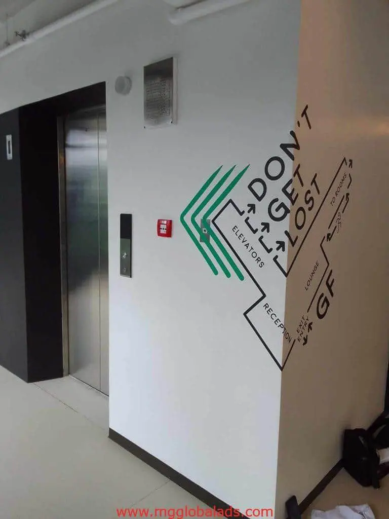 Metallic directional and wayfinding signage for elevators in Makati, featuring arrows, by M&G Global Ads.