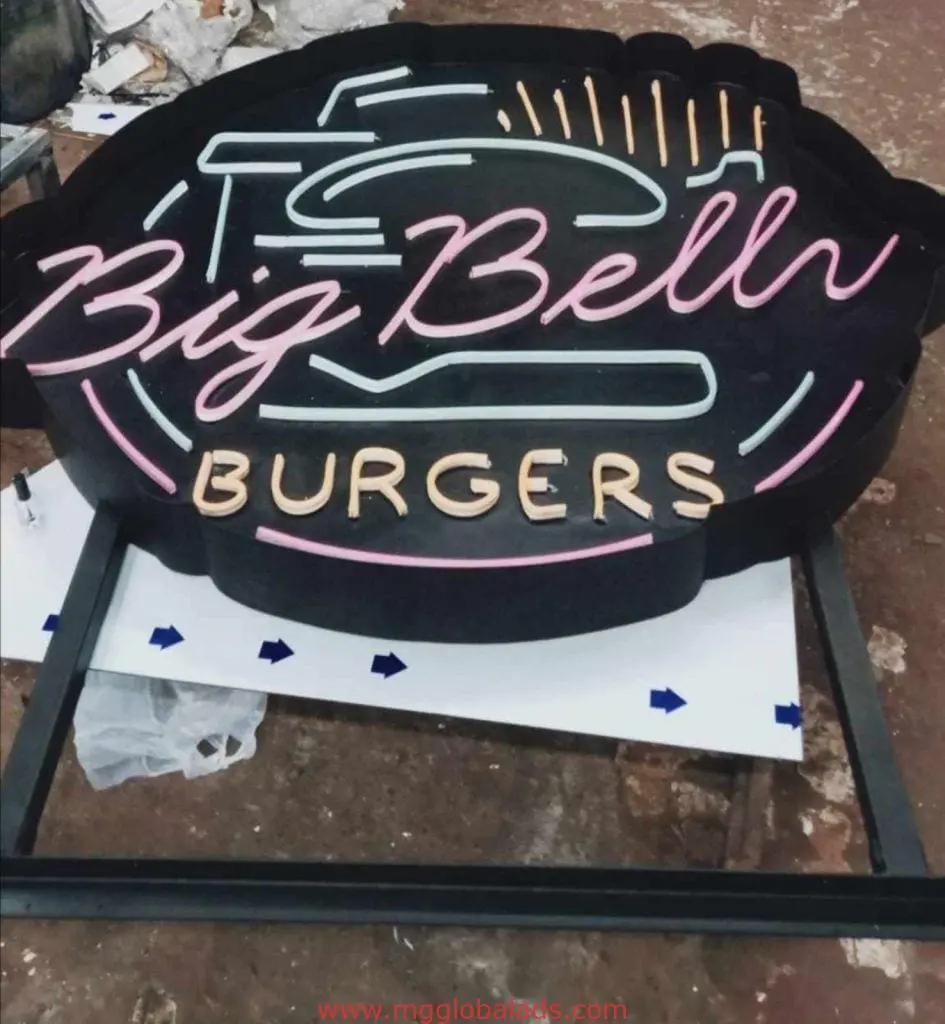 LED neon outdoor signage for Big Bell Burgers in pink and yellow, on the ground with debris, Ortigas location by M&G Global Ads.