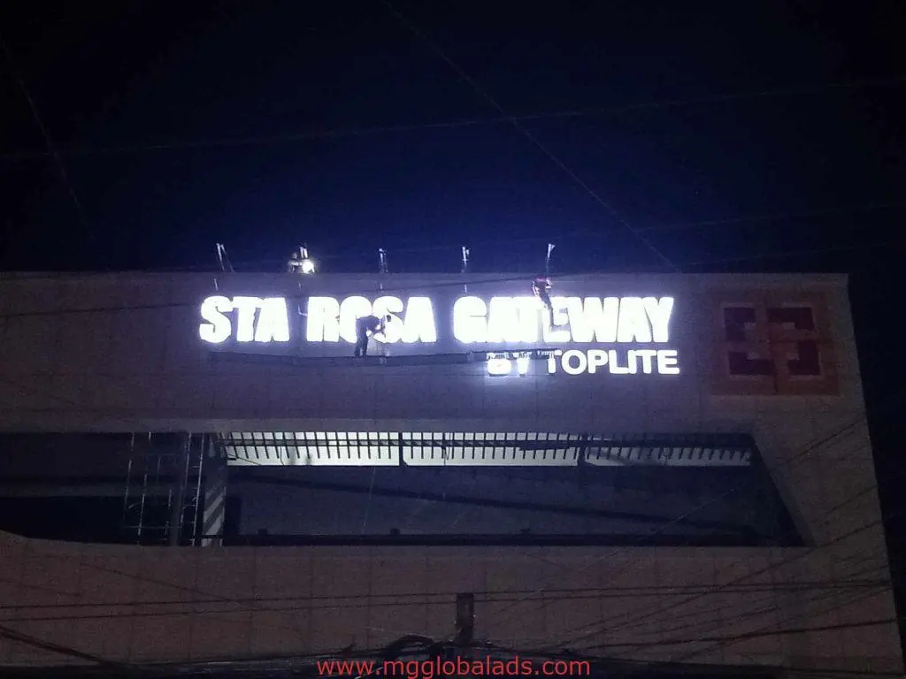 LED signage installation for STA ROSA GATEWAY by Toplite in Makati, workers use harnesses and ladders for safety by M&G Global Ads.