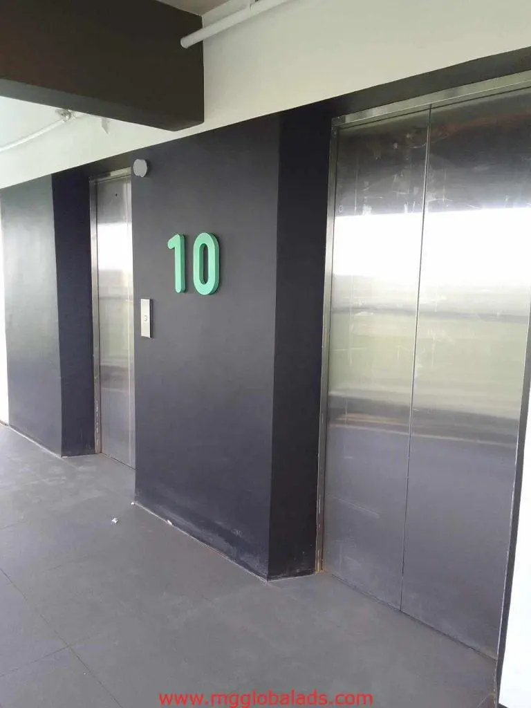 Bold acrylic floor number signage, 10th floor elevator lobby in Makati, silver doors, button panel, by M&G Global Ads.