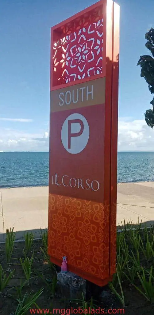 Outdoor pylon signage for IL CORSO with SOUTH and P symbol, beach view, blue sky in BGC by M&G Global Ads.