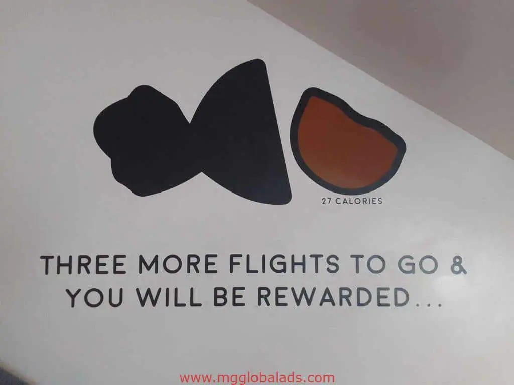 Outdoor building signage in Makati with black fish, orange slice, 27 CALORIES; reward message. By M&G Global Ads.