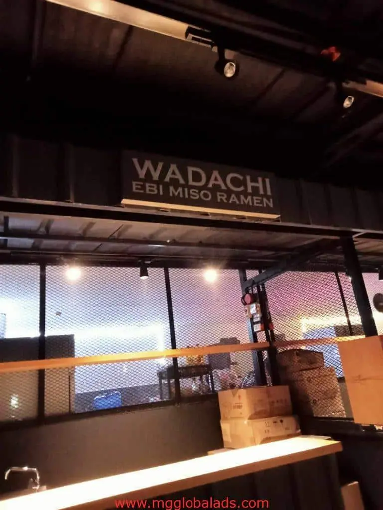 Indoor restaurant signage for WADACHI EBI MISO RAMEN in Makati above counter, mesh partition visible—by M&G Global Ads.