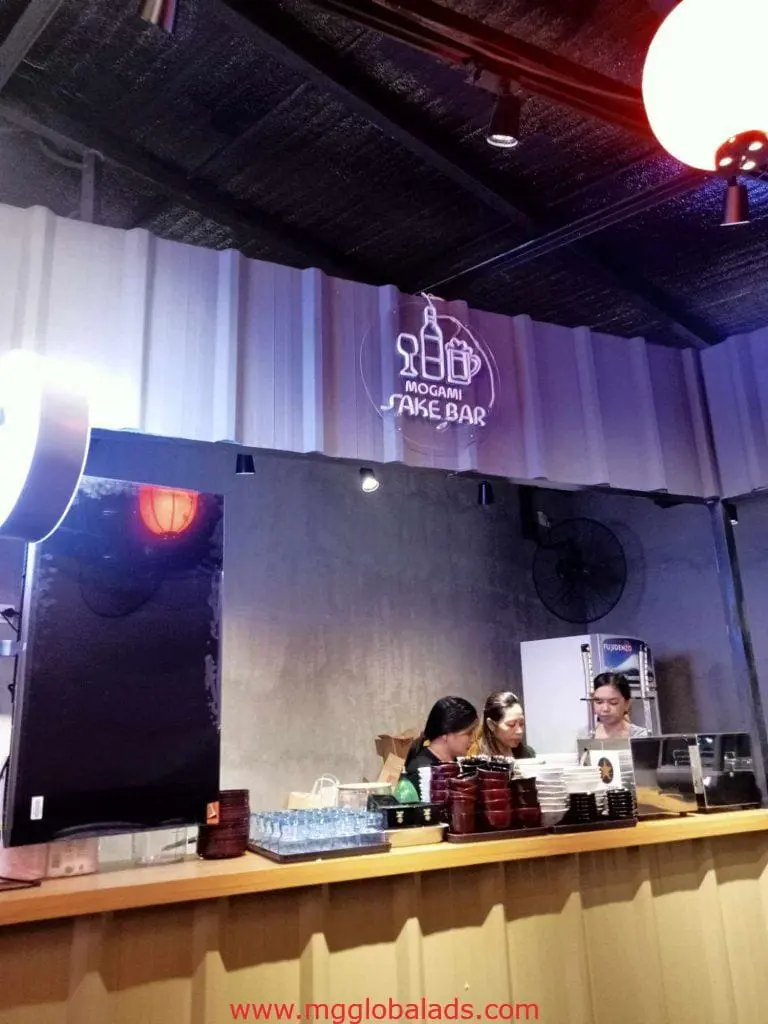 Mogami Sake Bar metallic sign and LED signage in Makati, warm-lit modern bar interior with staff by M&G Global Ads.