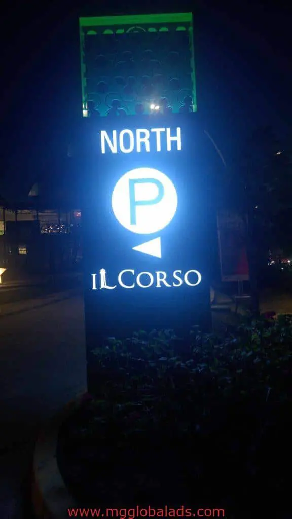 Glowing outdoor directional signage for Il Corso parking in Makati, with arrow, at night by M&G Global Ads.