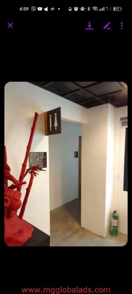 Womens restroom indoor signage in Makati building hallway, fire extinguisher and red decor visible, by M&G Global Ads.