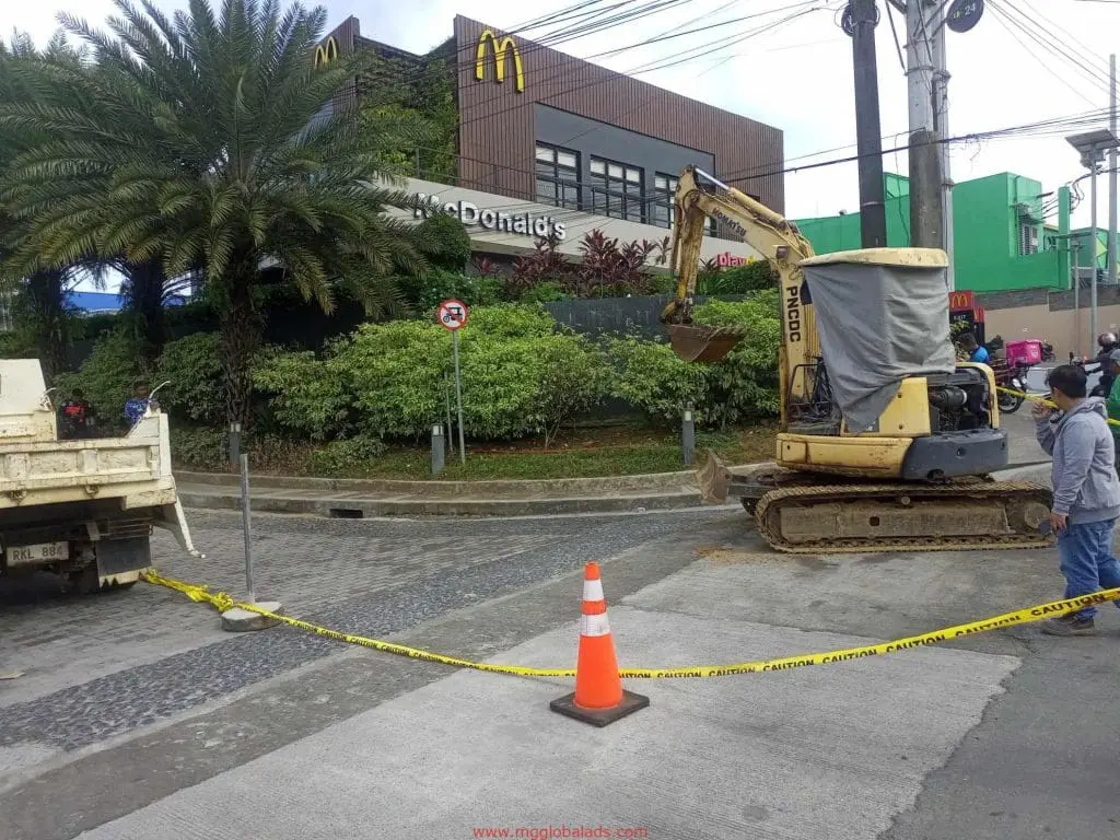 McDonald’s LED signage installation with truck and excavator in Ortigas, cobblestone road blocked, by M&G Global Ads.