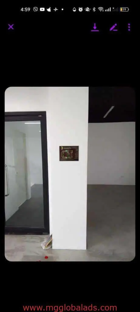 LED floor plan signage on a white wall in Quezon City office, glass door left, open room right, by M&G Global Ads.