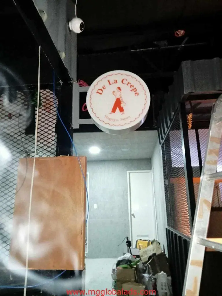 Round LED shop signage for De La Crepe with chef logo in Makati, installation in progress by M&G Global Ads.