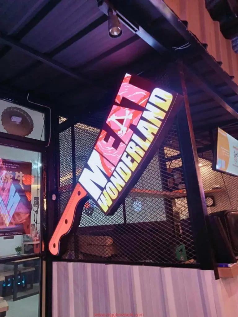 Illuminated metallic meat cleaver restaurant signage for MEAT WONDERLAND in Makati at night, by M&G Global Ads.