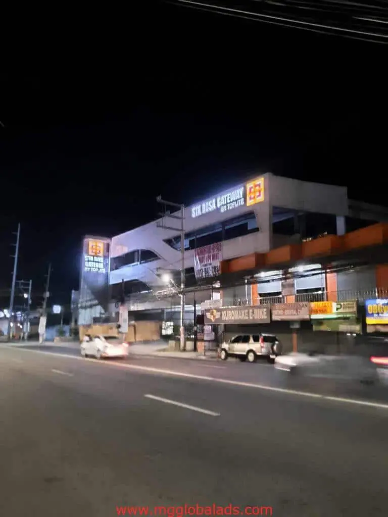 Sta. Rosa Gateway LED signage for client, night scene in Ortigas with cars, motorcycles, shops. by M&G Global Ads.