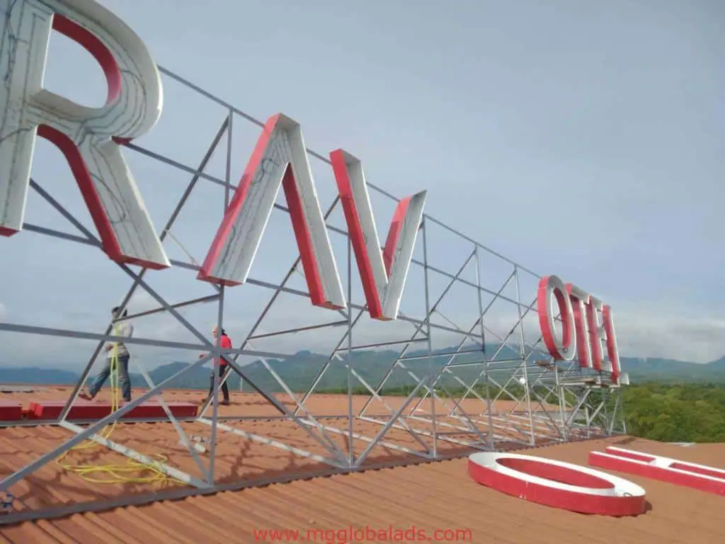 Rooftop channel letter signage installation in Ortigas, with worker and greenery background, by M&G Global Ads.